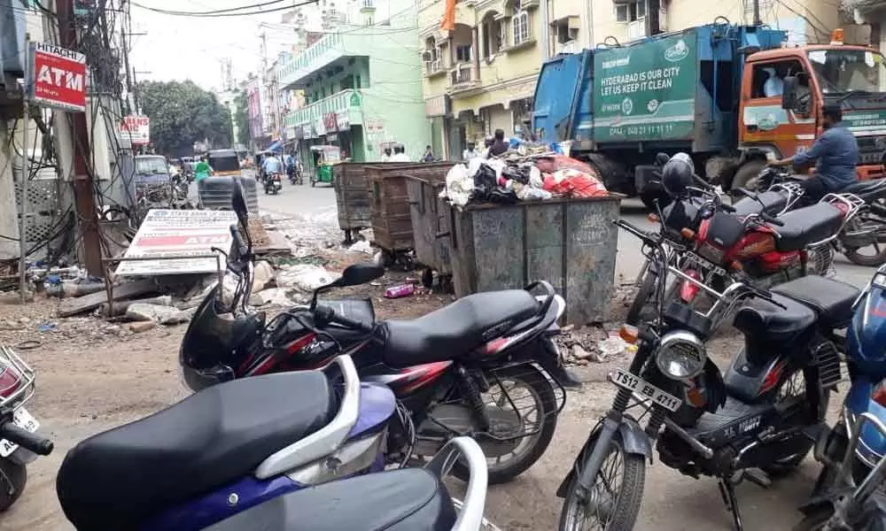 Garbage containers, bins occupy road