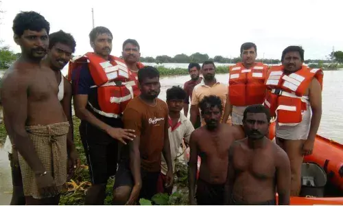 Fire and police personnel rescues three persons stuck in the flood waters at Revanur village.