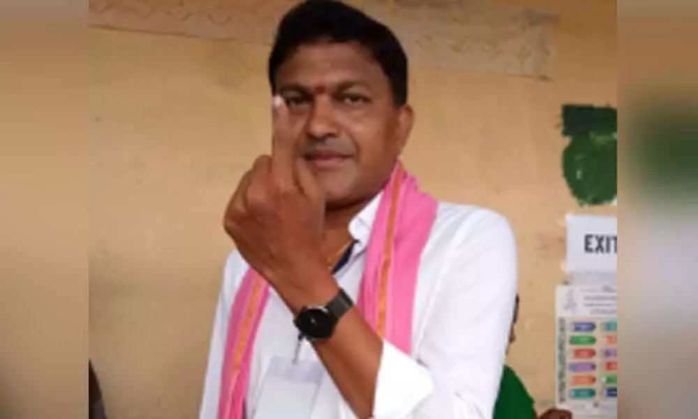 TRS MLA candidate Shanampudi Saidi Reddy showing his ink mark after casting his vote at a polling center located at  his native place gundlapally of Mattampally