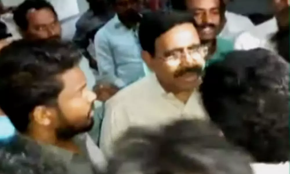Students obstruct former minister Narayana and pull off his shirt