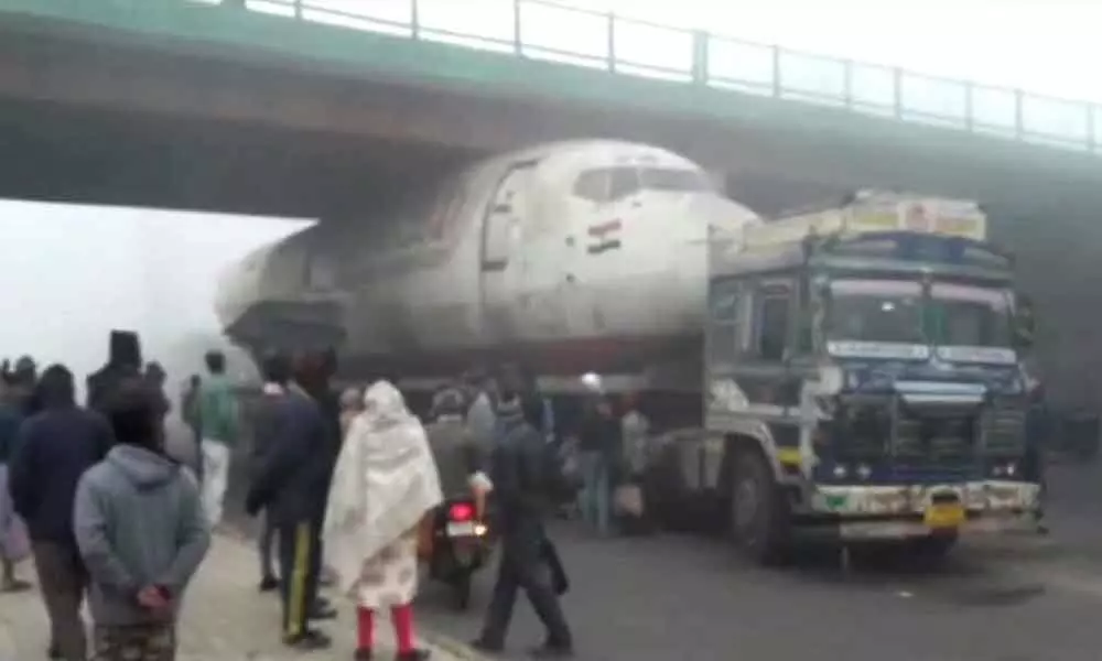 Truck carrying abandoned India Post aircraft gets stuck under a bridge in Bengal