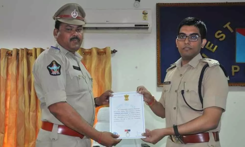 SP Navadeep Sing presents merit certificate to a cop in Eluru