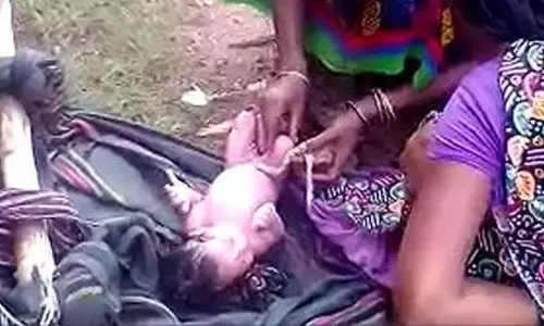 Pregnant Tribal woman carried on a makeshift stretcher gives birth on the road in Vizianagaram