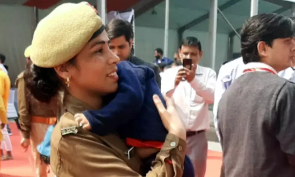On-duty woman cop carries infant son in arms at Yogi Adityanath event in Noida. See viral pic
