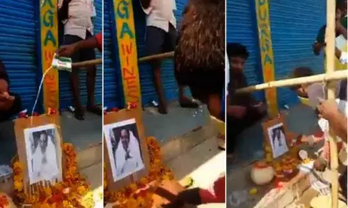 Tipplers perform Palabhishekam to CM KCRs portrait for opening liquor shops