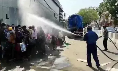 Migrant workers sprayed with disinfectant in south Delhi