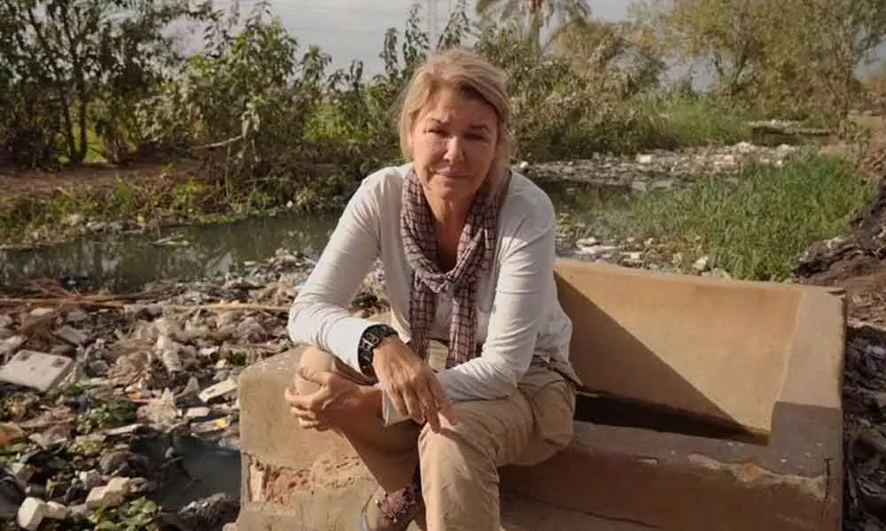 Crawford sitting near mounds of plastic by the Nile