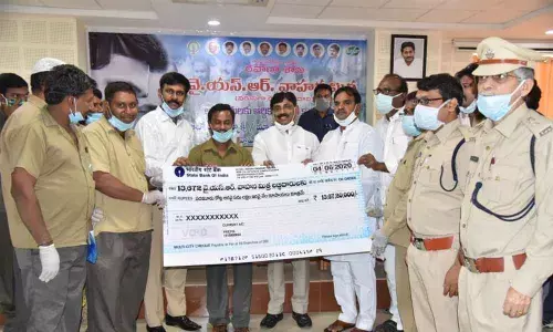 Deputy Chief Minister Amzath Basha distributing cheques to the beneficiaries under YSR Vahana Mitra Scheme in Kadapa on Thursday