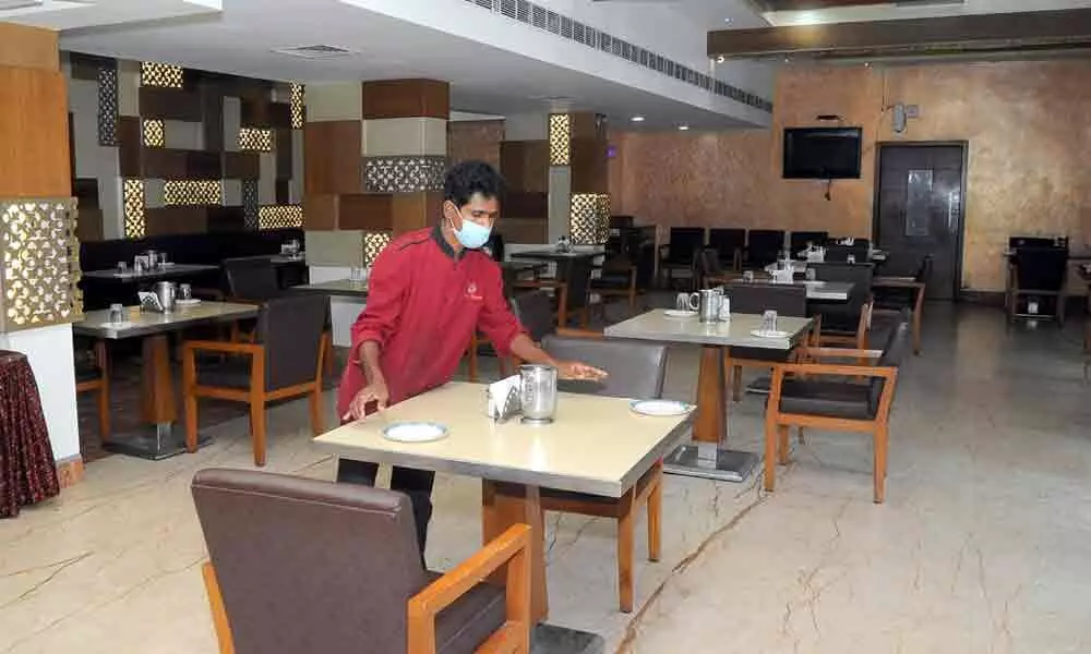 A staffer arranging tables at a hotel in Vijayawada on Sunday  	Photo: Ch Venkata Mastan