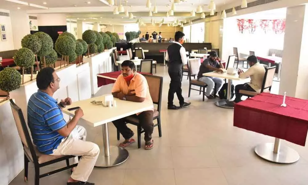 Customers sit in a restaurant after authorities allowed the opening of eateries  during the fifth phase of lockdown in Vijayawada on Monday 	Photo: YVinay Kumar