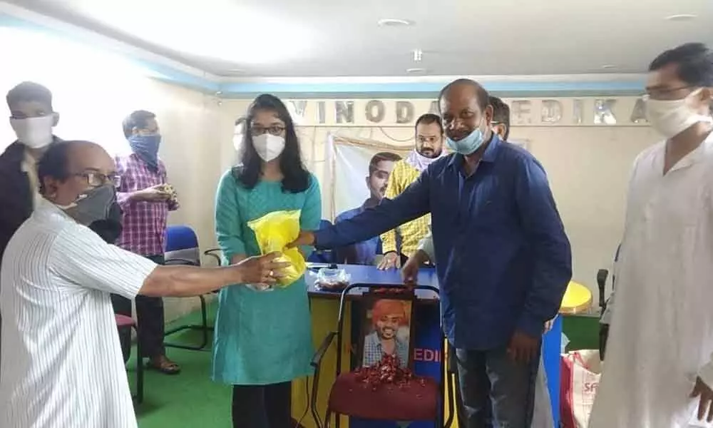 10 th class student Mula Janani distributing masks and sanitisers to media persons in Visakhapatnam on Thursday