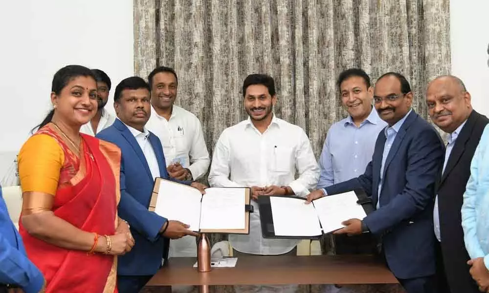 Special Chief Secretary (Industries) R Karikal Valaven exchanging copies of agreement with representatives of GMR Group in the presence of Chief Minister Y S Jagan Mohan Reddy at his camp office at Tadepalli on Friday. Industries Minister M Goutham Reddy, APIIC chairperson R K Roja, GMR Group chairman GBS Raju and others are seen.