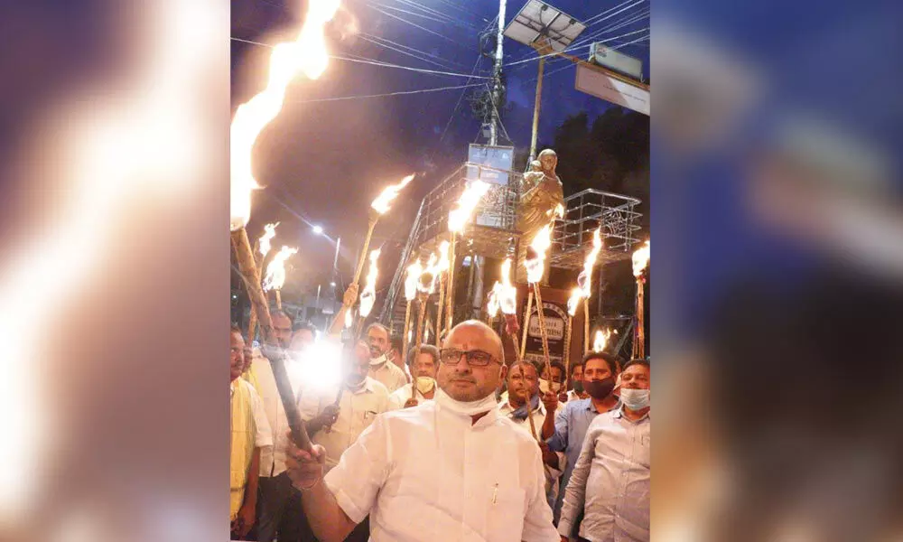 TDP leaders stage a protest with torches against the arrest of K Atchannaidu