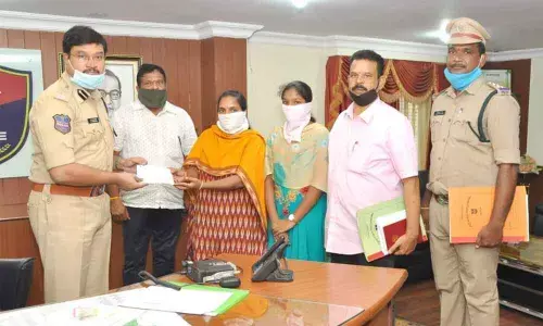 SP AV Ranganath presenting Cheyutha cheque for Rs 2 lakh to the widow of AR head constable Mallesham at his chamber in Nalgonda two days ago