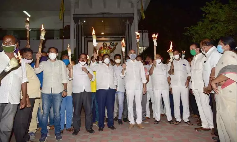 MP Galla Jayadev, TDP Guntur urban president Degala Prabhakar and other party leaders staging torch light protest in Guntur on Sunday
