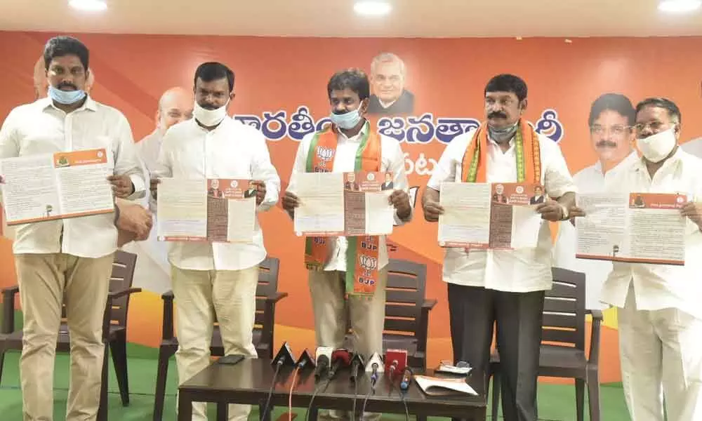 BJP leaders unveil brochures marking the first anniversary of Modi 2.0, in Visakhapatnam on Sunday