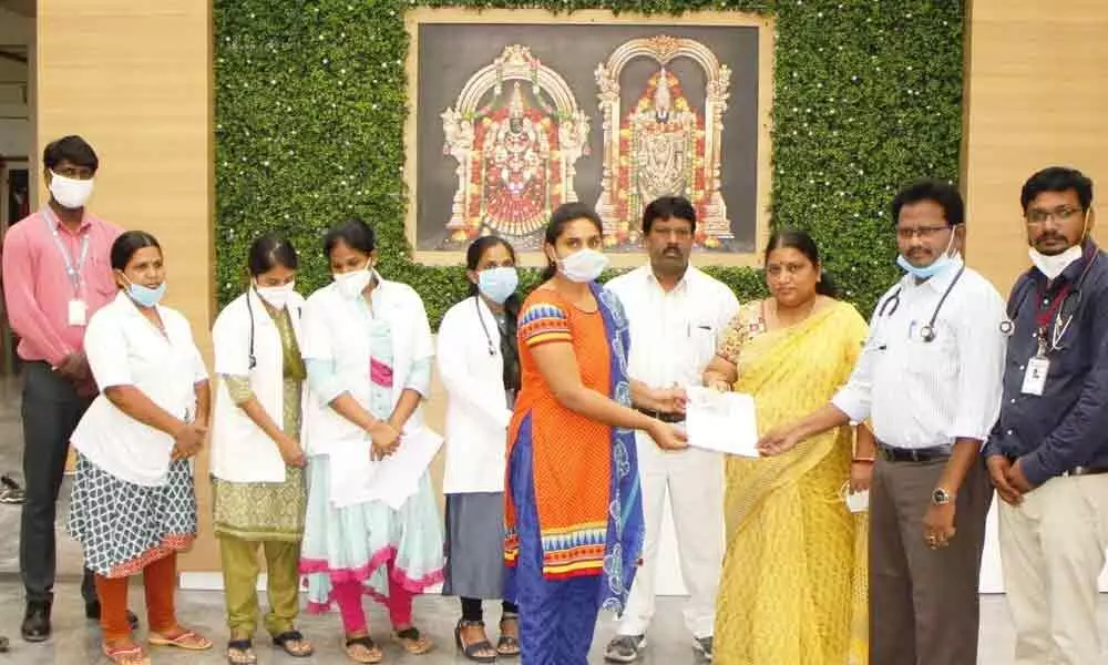 TUDA Secretary and Sri Padmavati Nilayam in-charge S Lakshmi giving away discharge summary to a patient in Tirupati on Tuesday