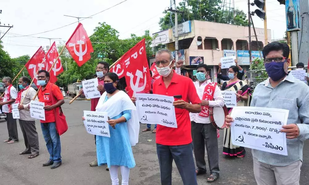 CPM leaders protesting with placards at Nandamganiraju junction in Rajamahendravaram on Tuesday