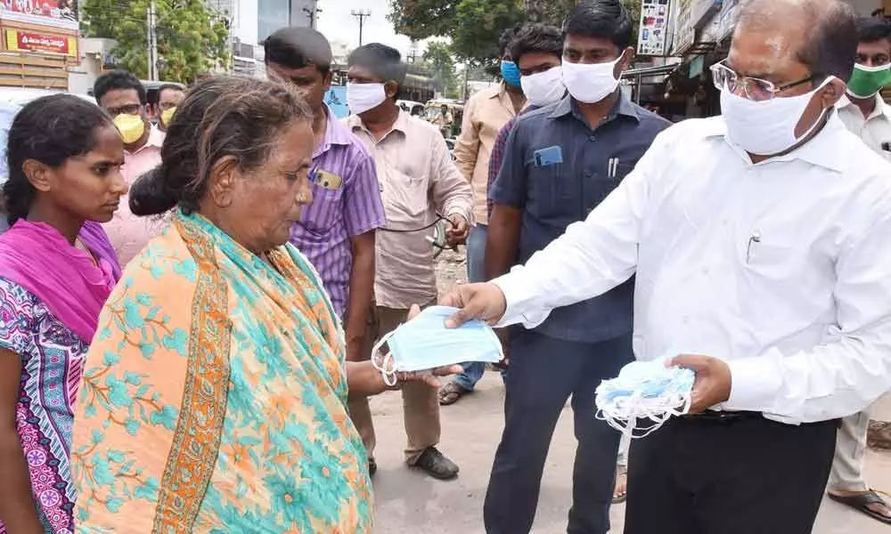 Krishna District Collector Md Imtiaz distributing masks to people in Vijayawada on Wednesday