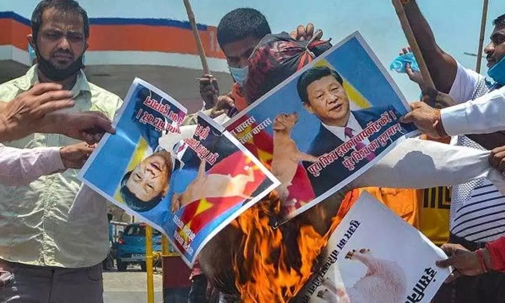 Demonstrators burn photos of Chinese President Xi Jinping during a protest against China on Indo-China clash