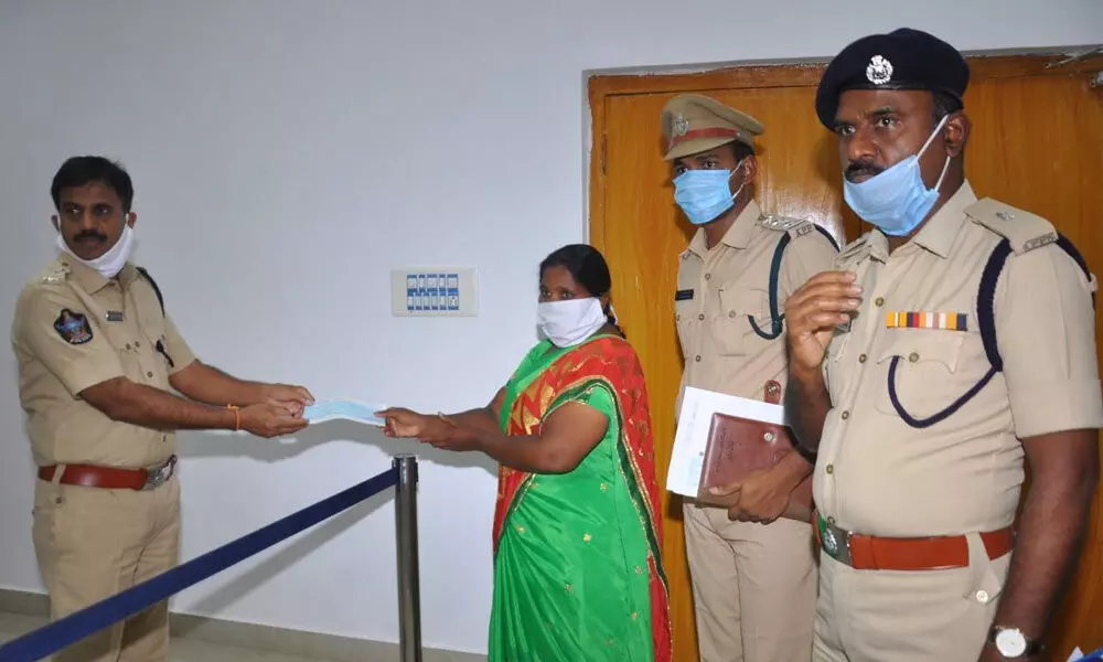 Superintendent of Police KN Narayan handing over a cheque to wife of a deceased home guard