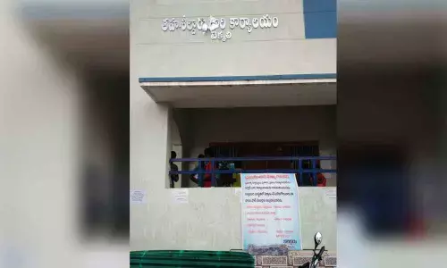 A flex board displayed in front of Tahsildar’s office requesting the visitors not to enter into office, at Tekkali in Srikakulam district