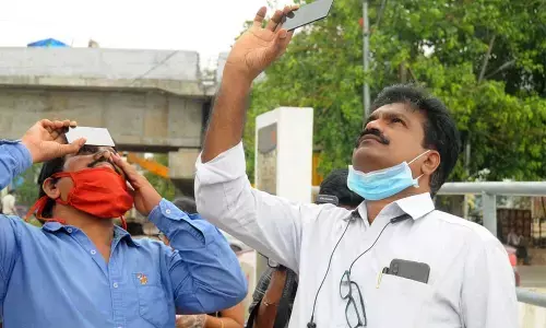 People watching solar eclipse at Prakasam barrage in Vijayawada on Sunday