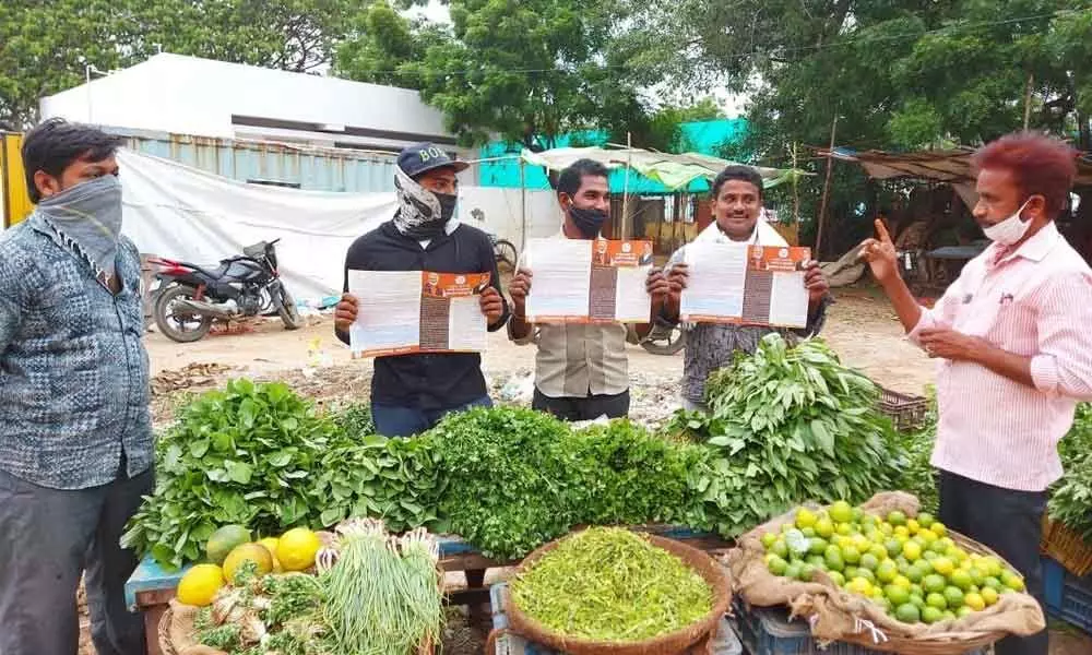 BJP leader Rambala Venkateswara Rao  briefing a vegetable vendor on the one year achievements of Modi government