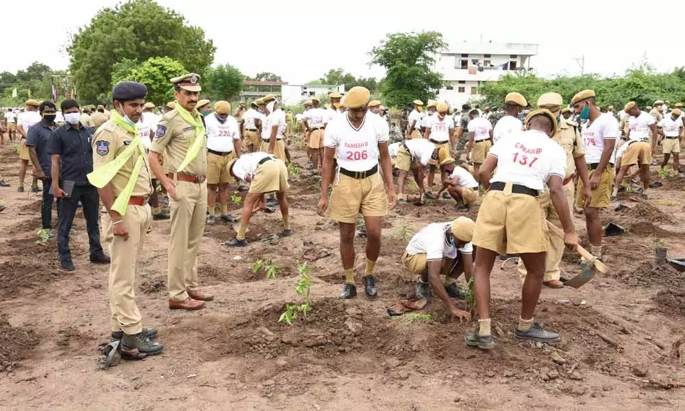 Police personnel preparing land for planting saplings in Police Training Centre in Karimnagar on Monday