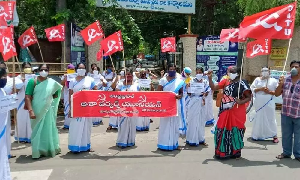 Asha workers staging dharna in front of Collectorate in Kakinada on Thursday