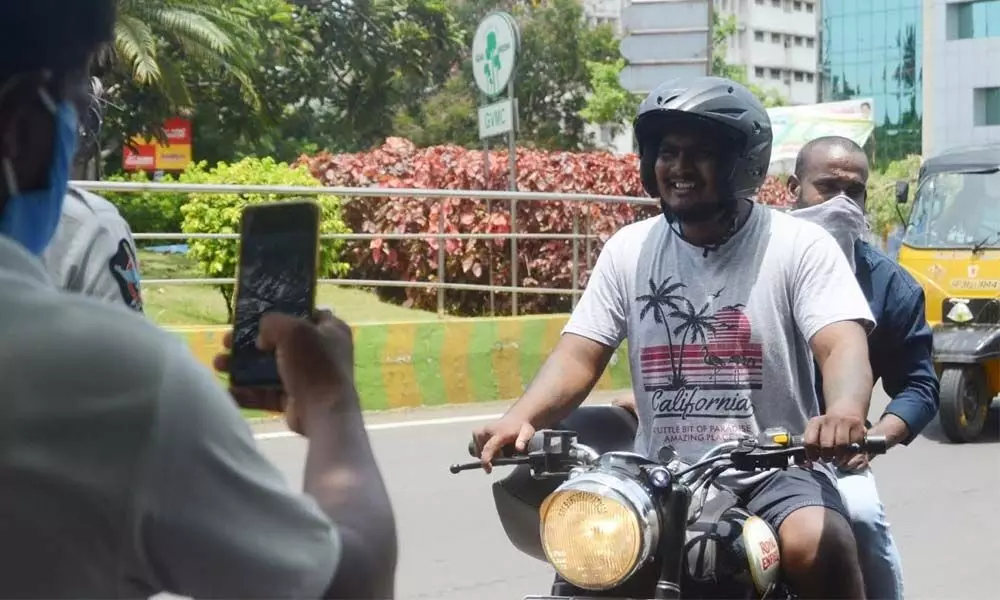 Police taking a photograph of a violator for not wearing a mask in Visakhapatnam.