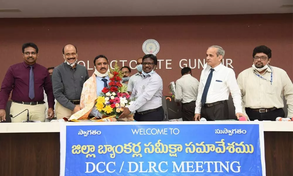 District Collector I Samuel Anand Kumar felicitating lead bank manager Venkateswara Rao in Guntur on Monday