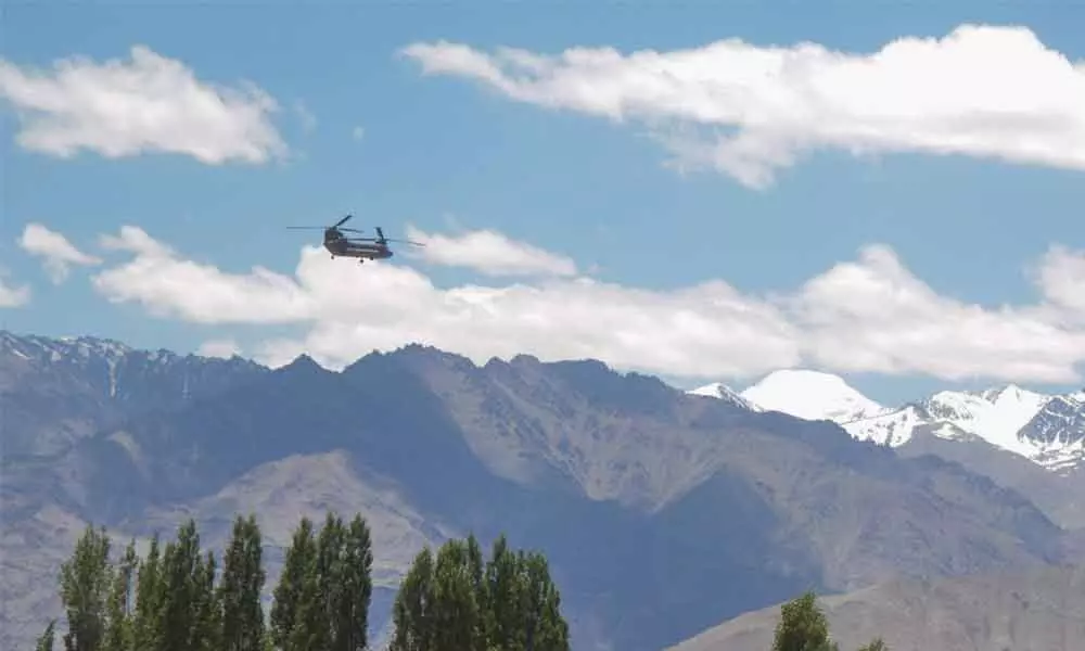 An Indian army Chinook helicopter flies from Air force base in the backdrop of a Himalayan mountain range, amid border tensions with China, in Leh on Wednesday