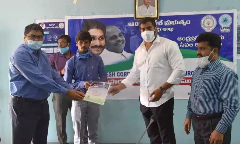 Minister Dr Anil Kumar and District Collector M V Seshagiri Babu handing over  order to an outsourcing employee at Collectorate in Nellore on Friday