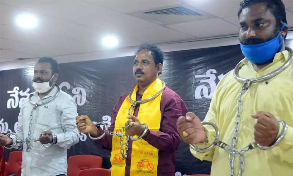 TDP urban president Vasupalli Ganesh Kumar staging a protest with handcuffs in Visakhapatnam on Friday