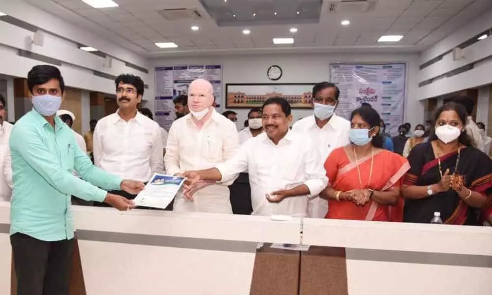 Rajya Sabha member Pilli Subhash Chandrabose handing over the appointment letter to an outsourced employee at Collectorate in Kakinada on Friday