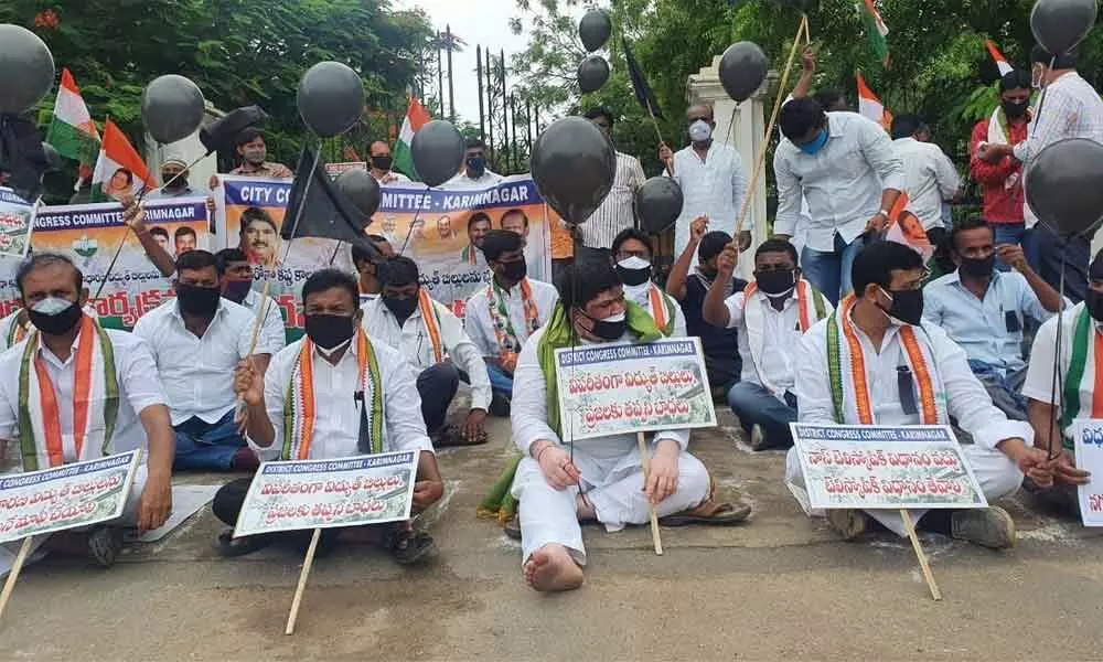 TPCC working president Ponnam Prabhakar along with Congress leaders staging a dharna in front of the SE office in Karimnagar on Monday