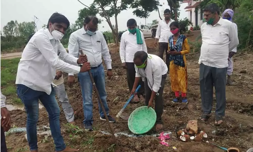 Sarpanch Kapil Patil laying foundation stone for the construction of crop drying platform in Nagalgaon village on Monday. ZP CEO Chander Nayak also seen