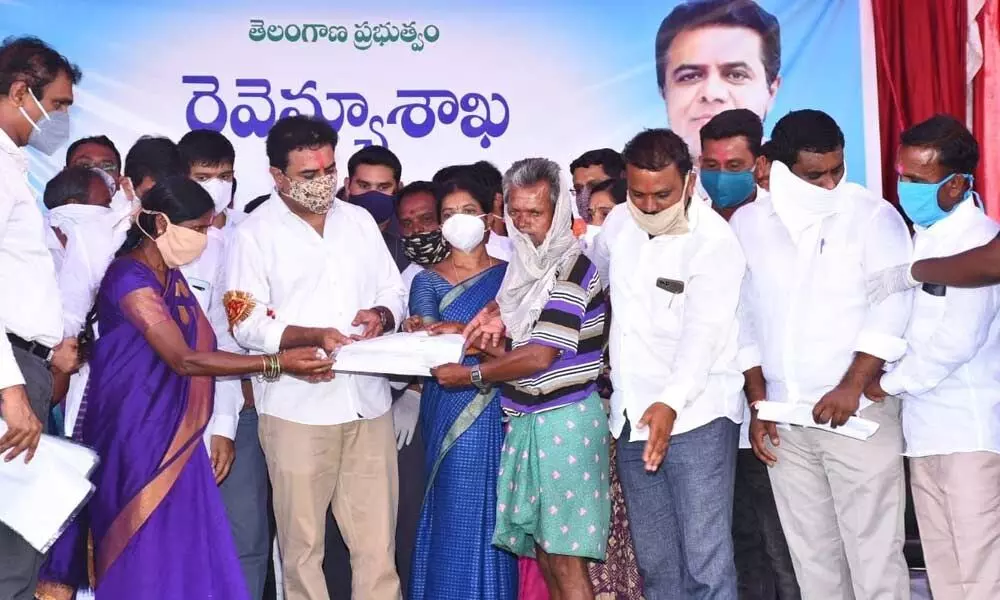 IT Minister KT Rama Rao distributing land patta to a beneficiary in Rangampet village on Tuesday