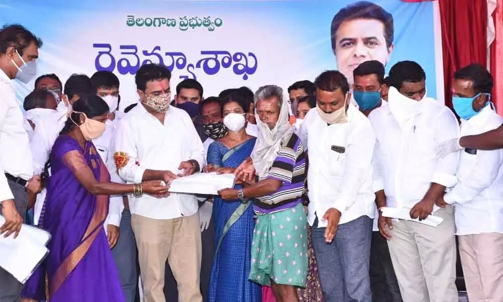 IT Minister KT Rama Rao handing over land patta to a beneficiary in Rangampet village on Tuesday