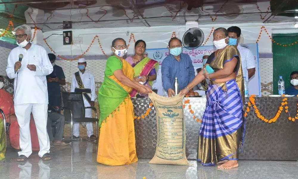 District Collector M Harijawaharlal distributing seeds to farmers at a programme