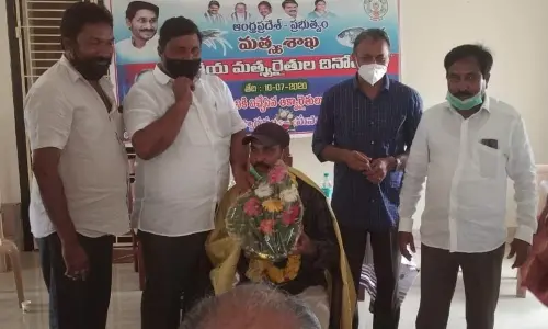 Fisheries Department Joint Director PK Rao felicitating Adarsha fish grower S Jagannadha Raju in Amalapuram on Friday