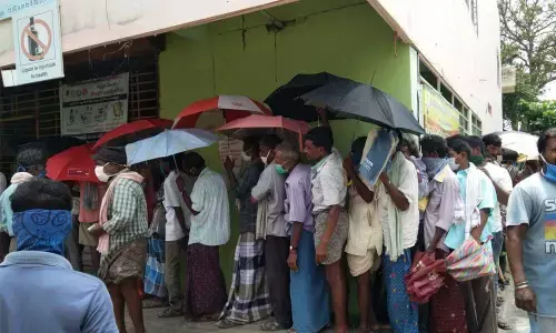 Boozers standing closely in front of a wine shop at Balaga in Srikakulam city on Saturday.