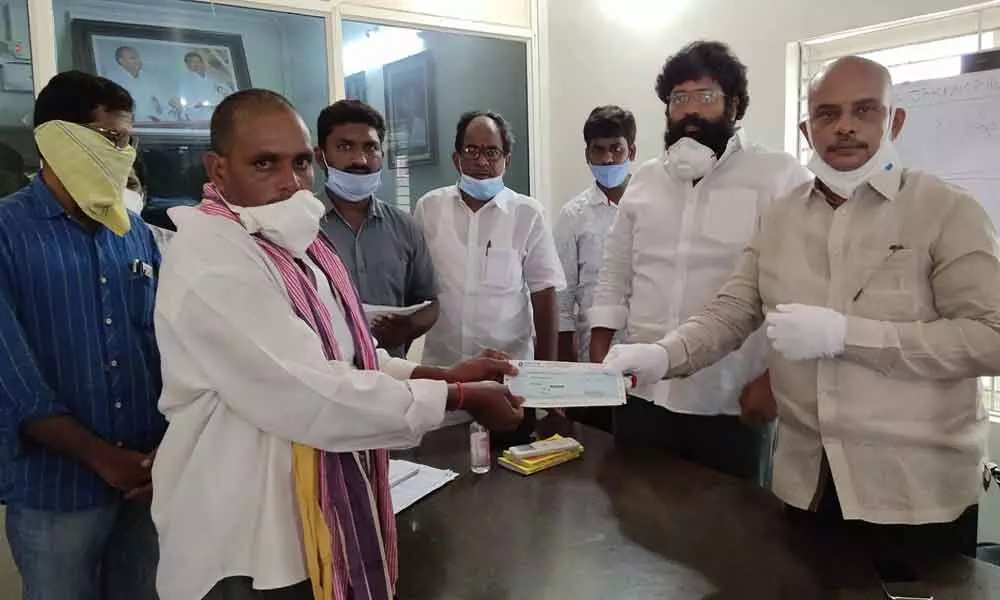 Rajanagaram MLA Jakkampudi Raja and YSRCP leader SSR Manyam distributing CMRF cheques to the beneficiaries at the legislator’s office in Rajamahendravaram on Sunday