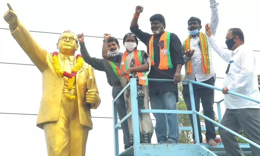 BJP SC Morcha leaders raising slogans after garlanding the statue of Dr B R Ambedkar in Vijayawada on Monday