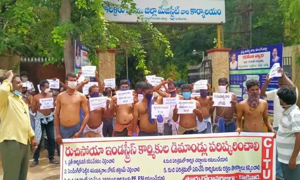 Ruchi company workers staging half-naked protest at the Collectorate in Kakinada on Tuesday