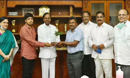 Chief Minister K Chandrashekar Rao greeting Jadcherla Degree College Botany Assistant Professor Sadasivaiah who set up a botanical garden on his college premises, at Pragathi Bhavan on Friday