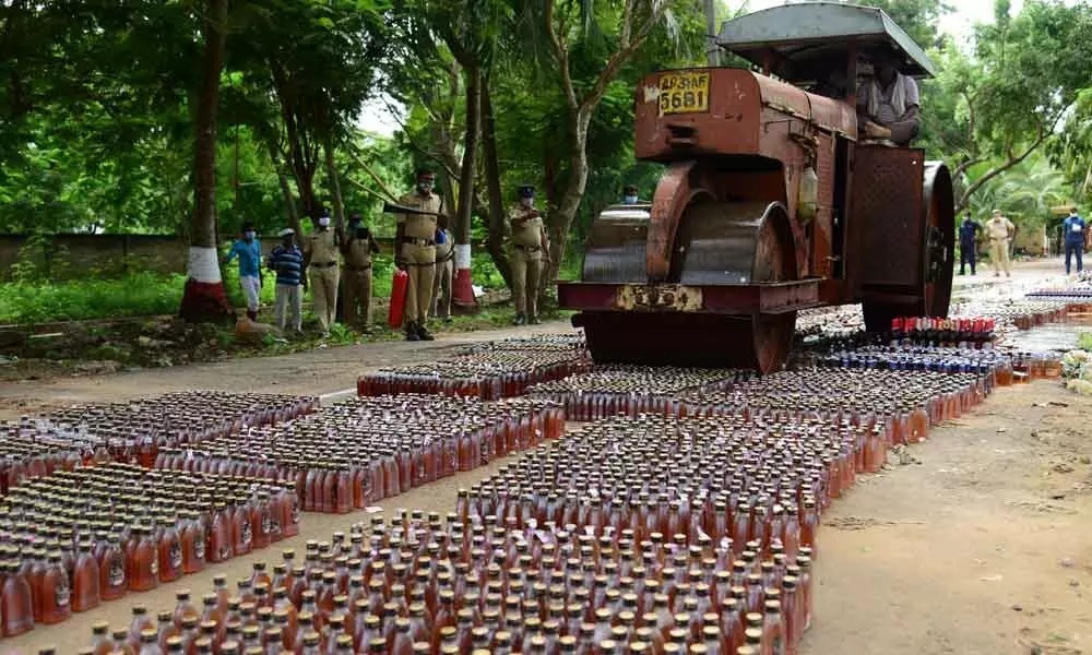 A road roller crushing liquor bottles in Machilipatnam on Friday