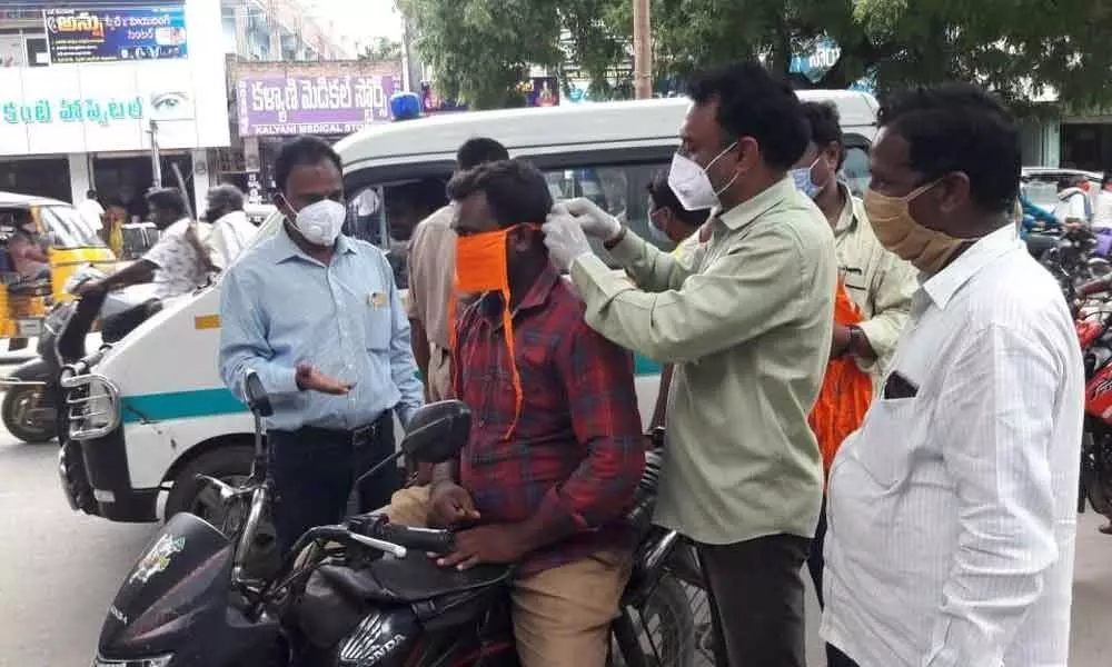 Suryapet: DMHO Karpuram Harsha Vardhan ties mask to a person