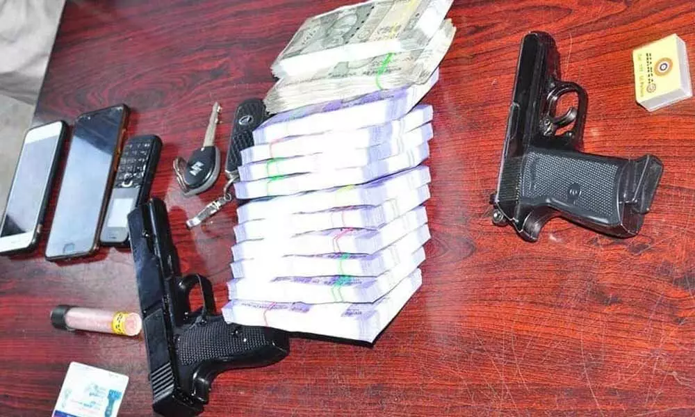 Police producing Rs 2.80 lakh cash, two air pistols and mobile phones seized from fake naxals